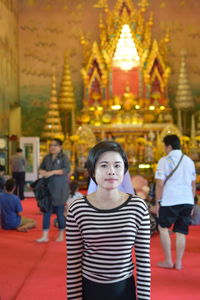 Portrait of young woman standing inside temple