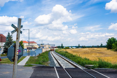 Railroad tracks amidst field against sky