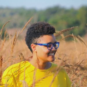 Portrait of young woman wearing sunglasses on field