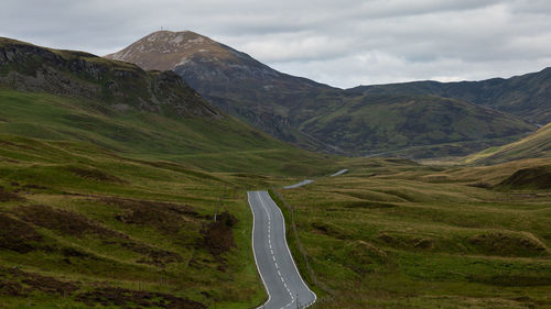 Scenic view of road amidst mountains against sky