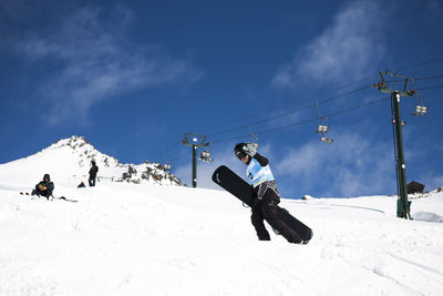 People skiing on snowcapped mountain against sky