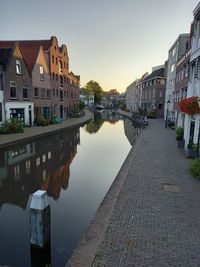 Reflection of buildings in canal against sky