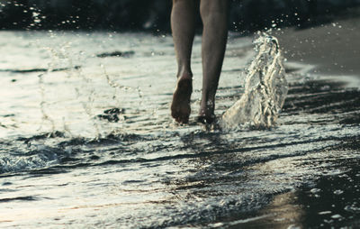 Low section of woman wading in sea