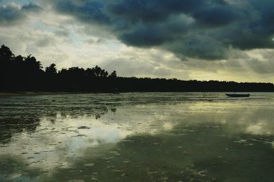 Scenic view of lake against cloudy sky