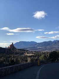 Road leading towards mountains against sky