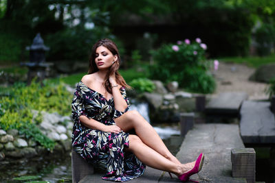 Fashionable young woman sitting outdoors