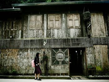 Full length woman walking by old building