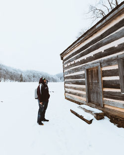 Man standing on snow covered field against sky