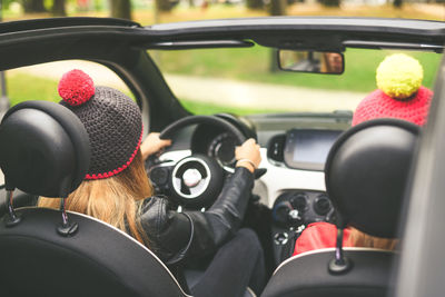 Girls sitting in the car. smiling teen in front of the steering wheel young women enjoying free time