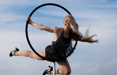 Midsection of woman holding hands against sky