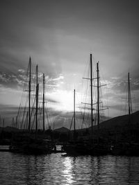 Sailboats in sea at sunset