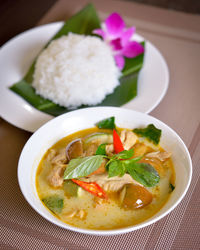 Thai food chicken green curry with rice in wood background