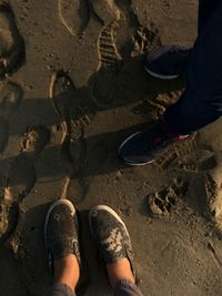 Low section of man standing on sand