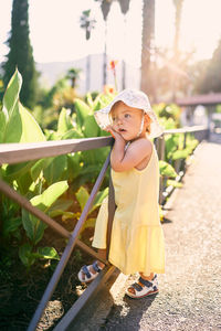 Cute girl standing against plants