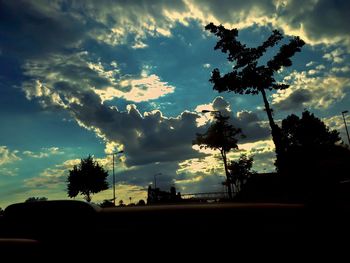 Silhouette trees against cloudy sky