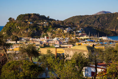 Scenic view of town by sea against sky