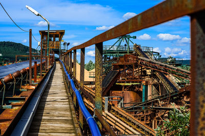 Metallic structure on bridge against sky