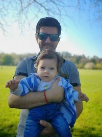 Portrait of father holding son while standing outdoors