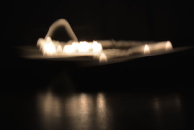 Close-up of lit candle in dark room