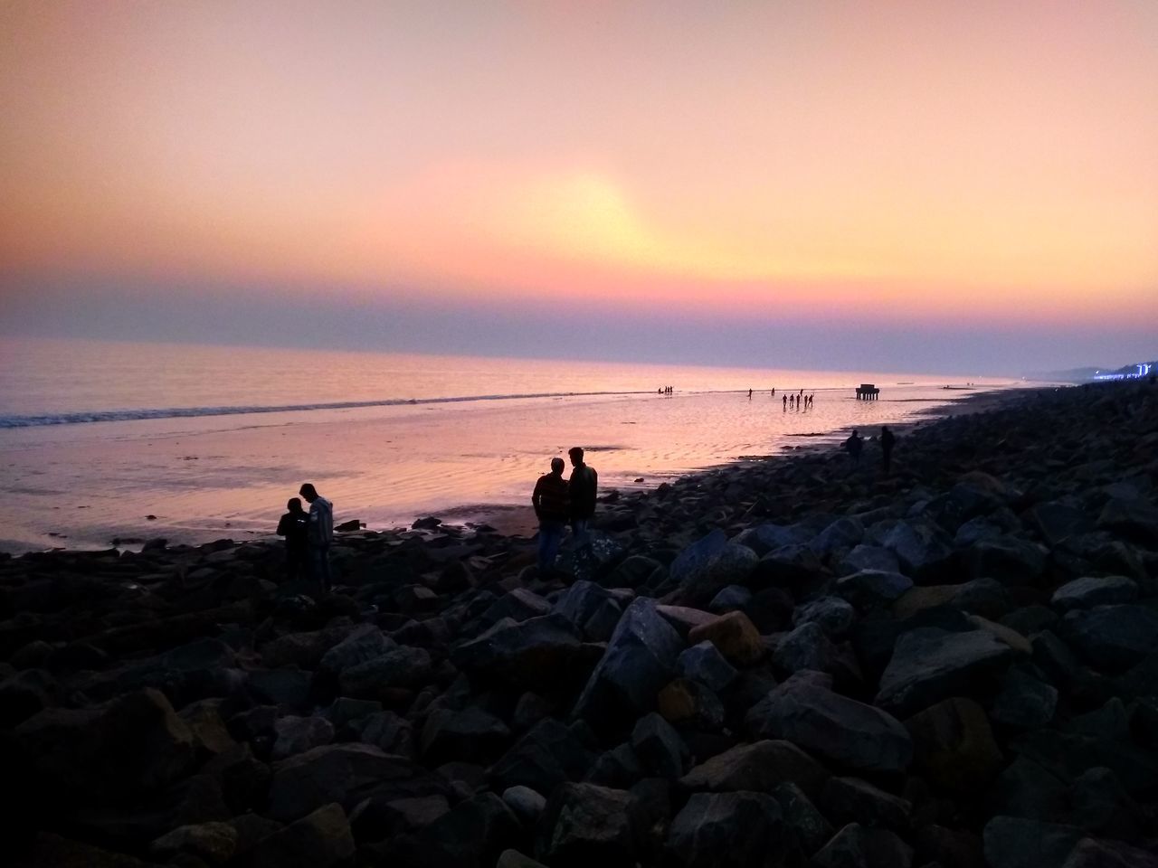 SCENIC VIEW OF ROCKS AT BEACH DURING SUNSET