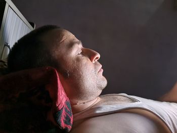 Side view of young man lying in bed