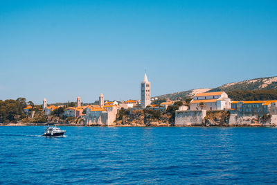 Boats in sea with buildings in background