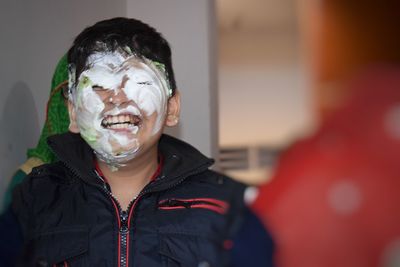 Close-up of boy with cake on face