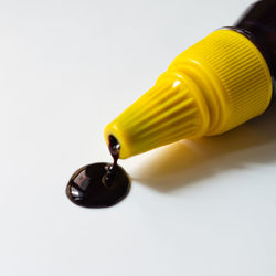 Close-up of yellow light bulb over white background