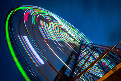 Low angle view of illuminated ferris wheel against sky at night