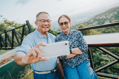 Portrait of couple standing against bridge