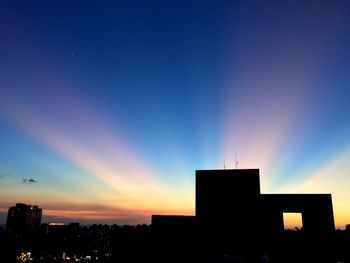 Silhouette buildings against sky during sunset