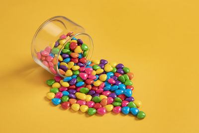 Colorful chocolate candy's, sugar coated chocolate gems candy on colorful background.