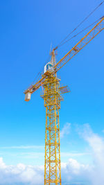 Low angle view of crane against clear blue sky