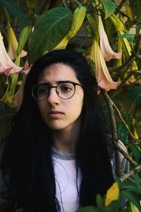 Young woman looking away against plants