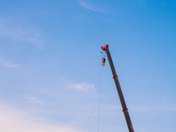 Low angle view of crane against sky