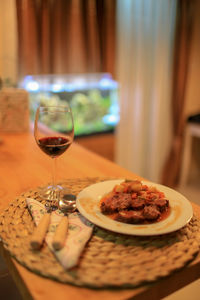 Close-up of food and red wine on table