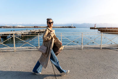 Rear view of woman standing on pier against sky