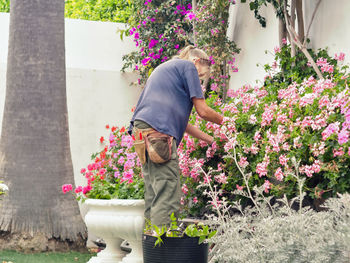 Woman standing by flower plants