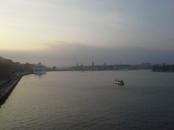 Boats in sea at sunset