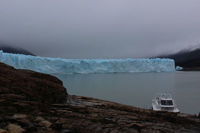 Scenic view of ice formation in sea against cloudy sky