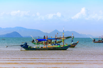 Boats moored in sea against sky