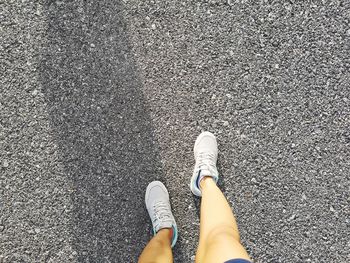 Low section of woman standing on road