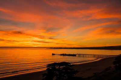 Scenic view of sea against cloudy sky during sunset