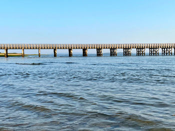 Bridge over sea against clear sky