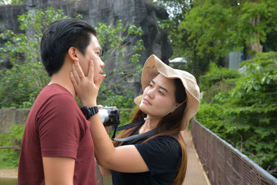 Woman touching man cheek while standing on footbridge