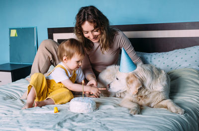 Labrador golden retriever with little child celebrate birthday with cake