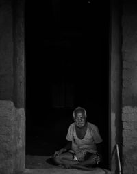 Portrait of smiling man sitting at entrance