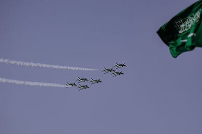 Low angle view of airplane flying against clear blue sky