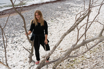 Full length portrait of young woman standing on land