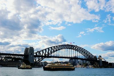 Bridge over river against cloudy sky